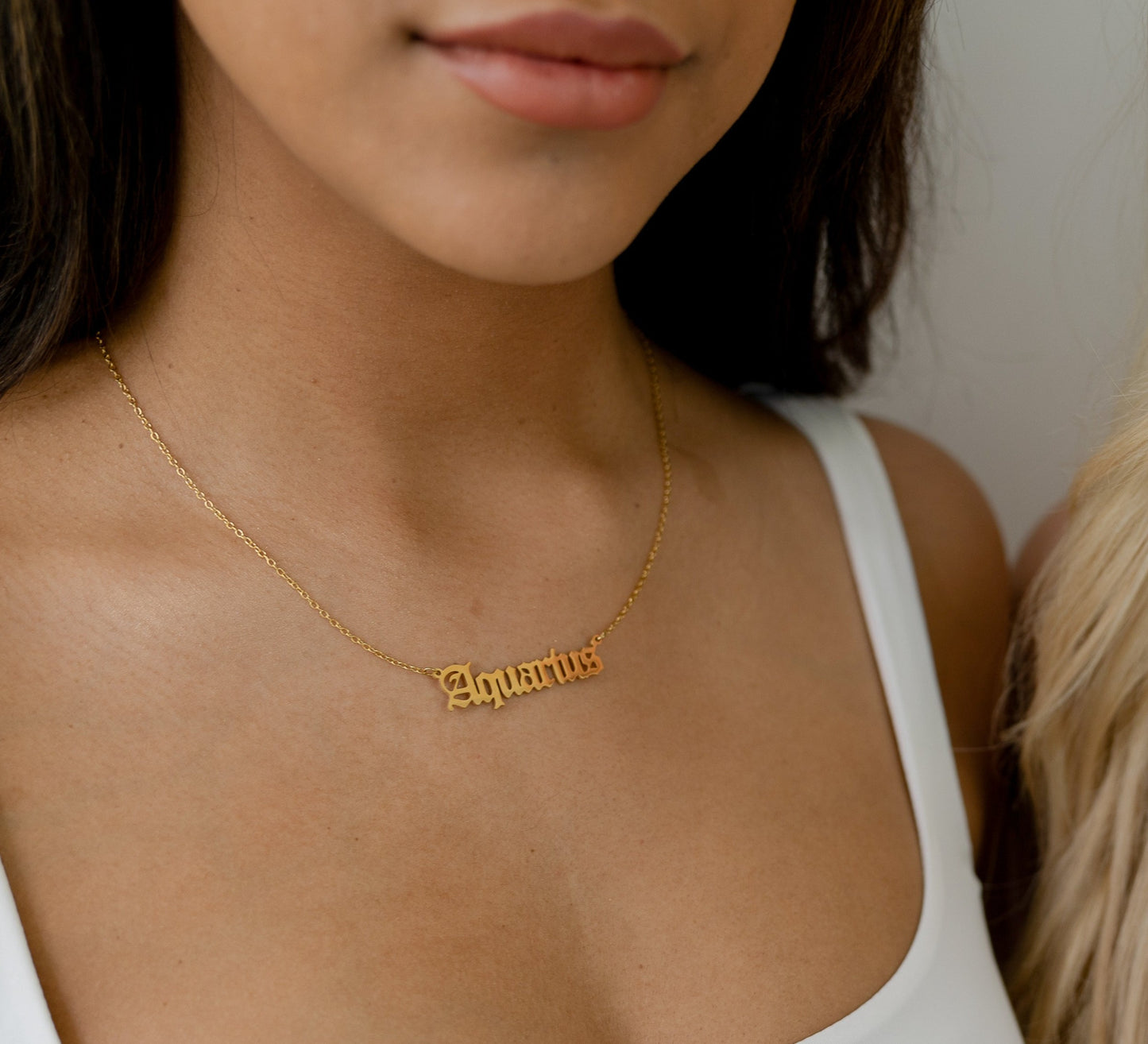 model wearing gold zodiac sign chain