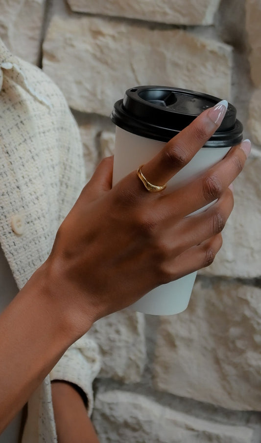 Model wearing unique wave style modern gold plated ring 